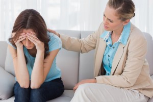 Worried woman being comforted by her therapist